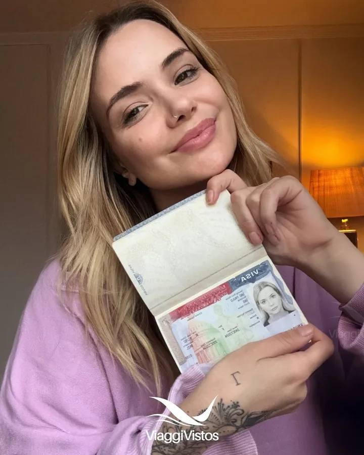 Cliente da Viaggi Vistos aprovada exibindo o passaporte com o visto americano